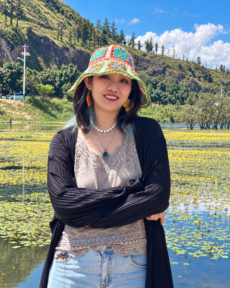 有苏 Yosu 在湖边自然微笑的个人照片,佩戴彩色帽子与珍珠项链